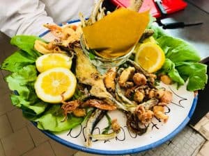 Frittura di Paranza con pesci freschi, croccanti e accompagnati da limoni e insalata. Perfetta per g.
